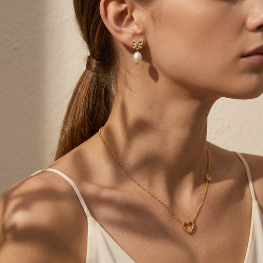 Bow cz freshwater pearl drop earrings - worn on ear