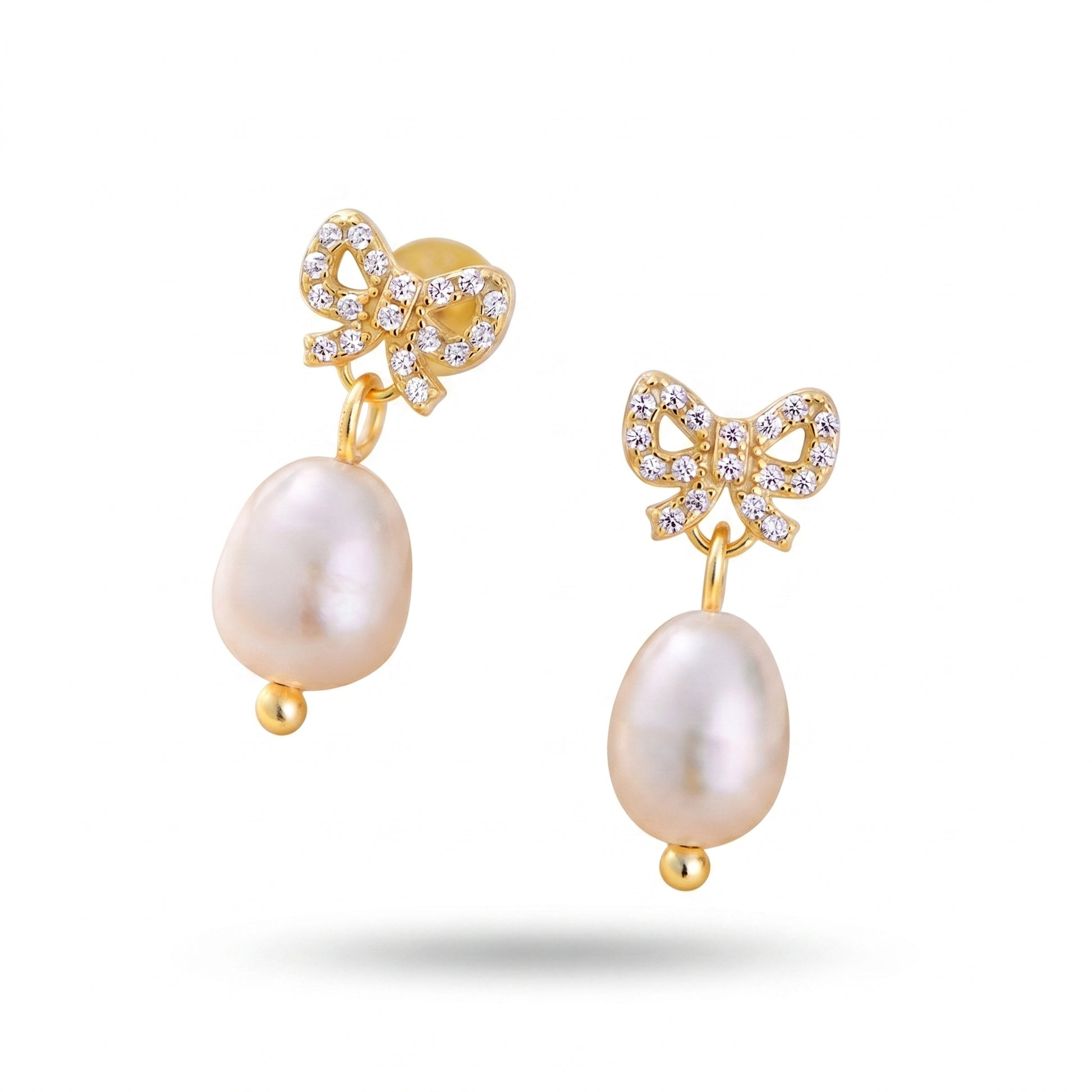 Close-up of gold plated bow cz freshwater pearl drop earrings