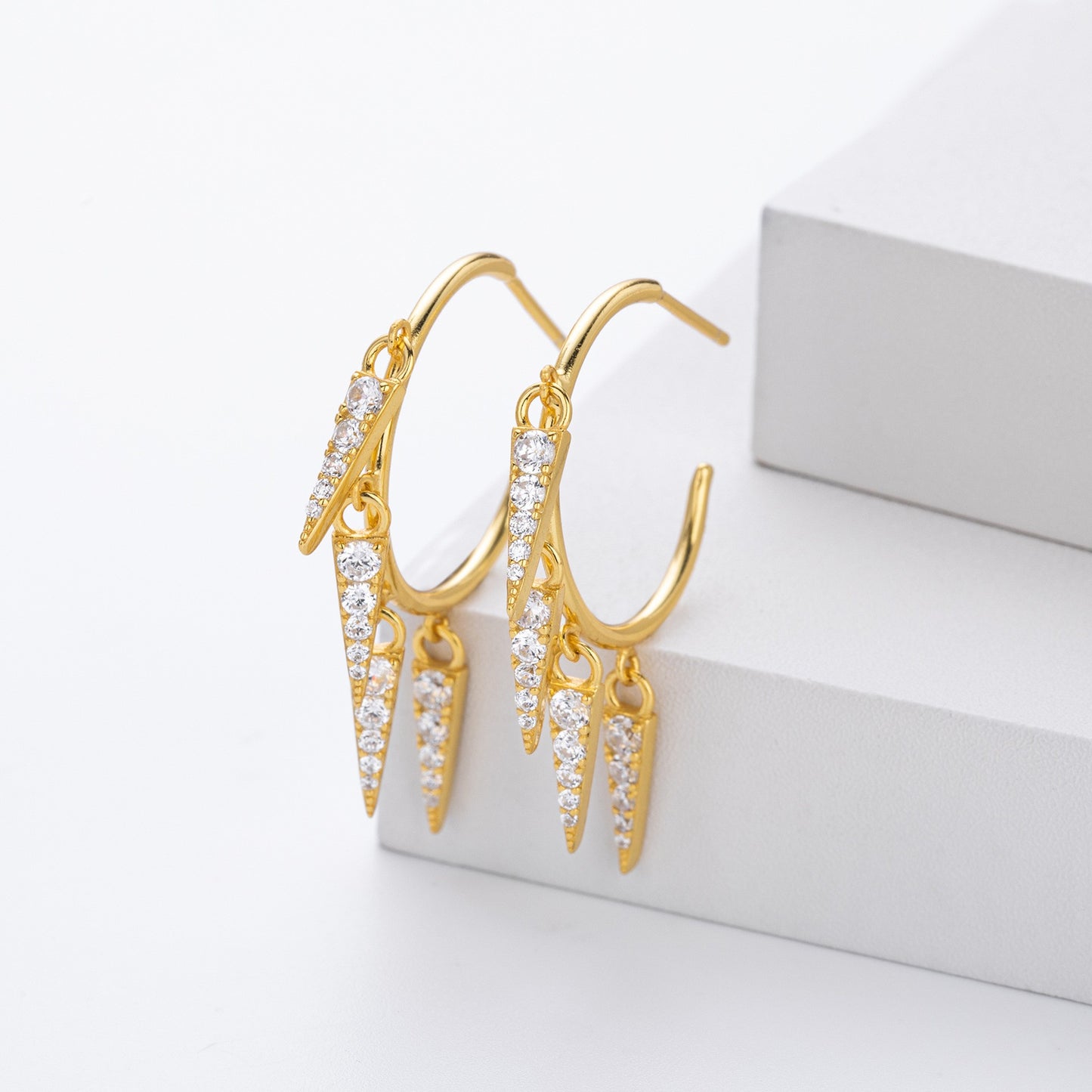 Close-up of gold plated spike cz drop hoop earrings