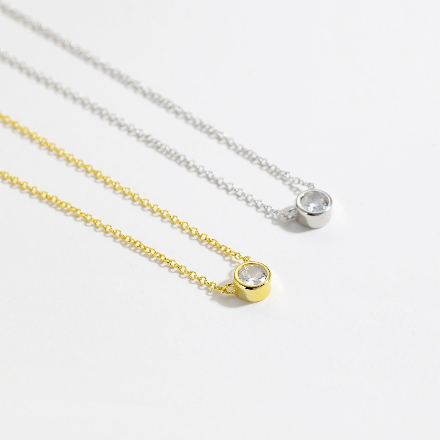 Gold and silver bezel-set solitaire cz necklace comparison