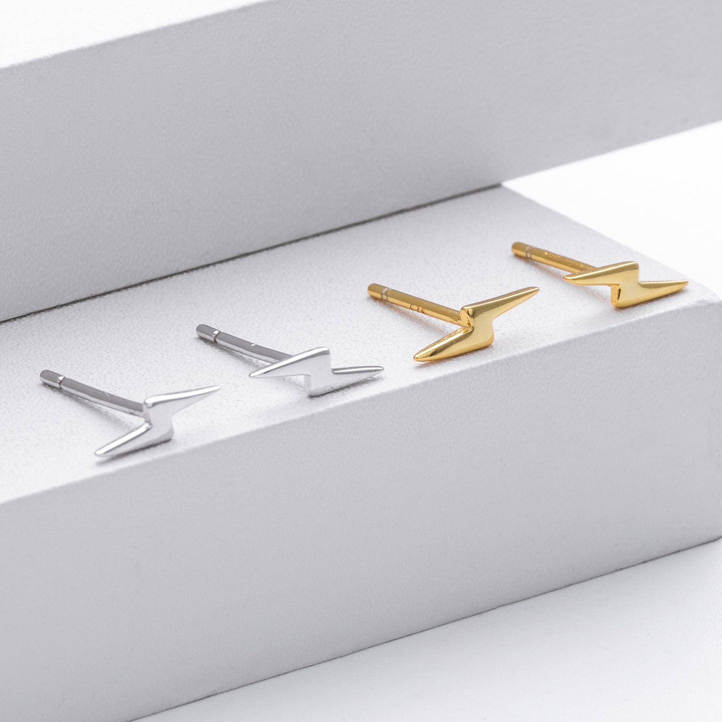 Gold and silver lightning bolt stud earrings in gift box