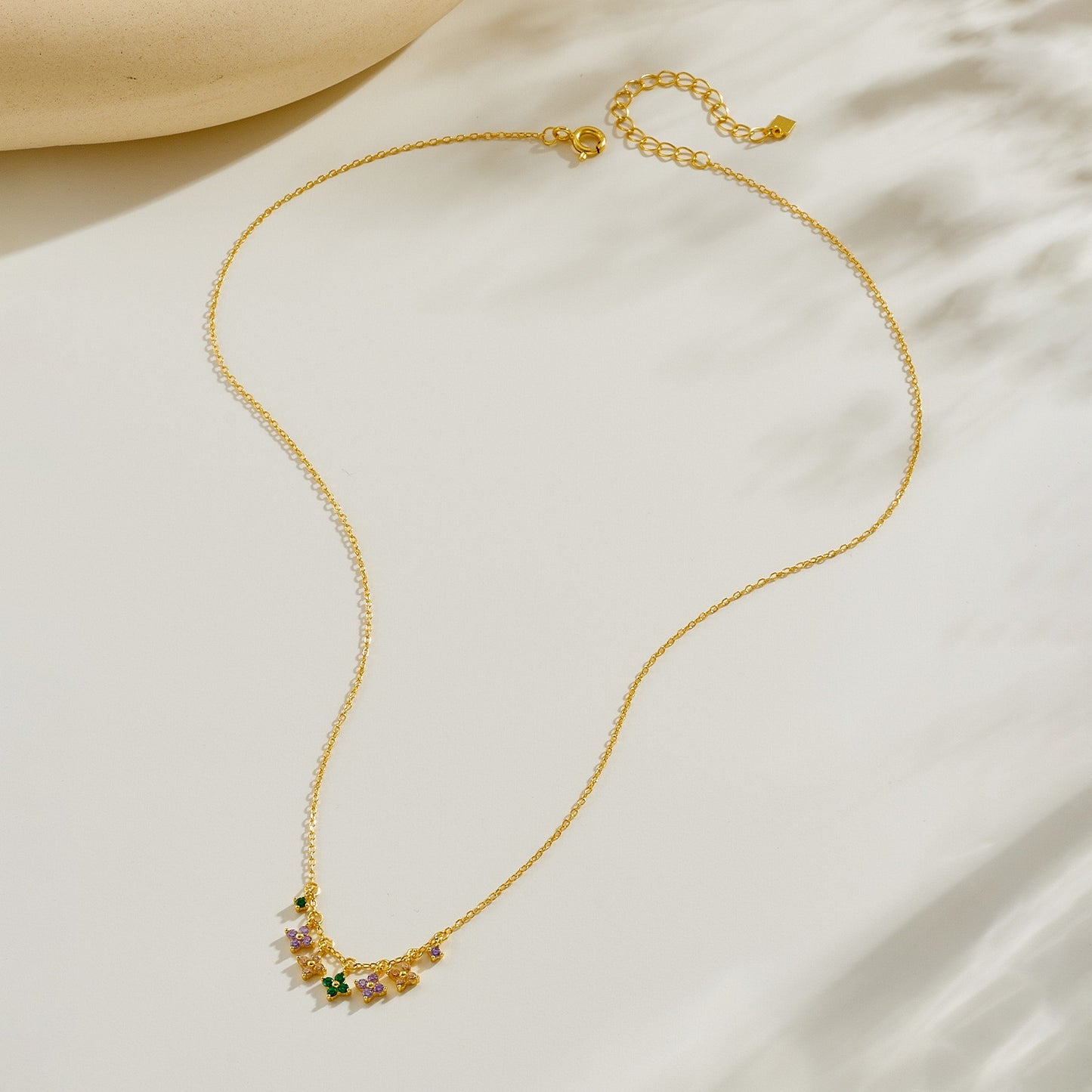 Gold plated multi-color clover charm necklace flat lay