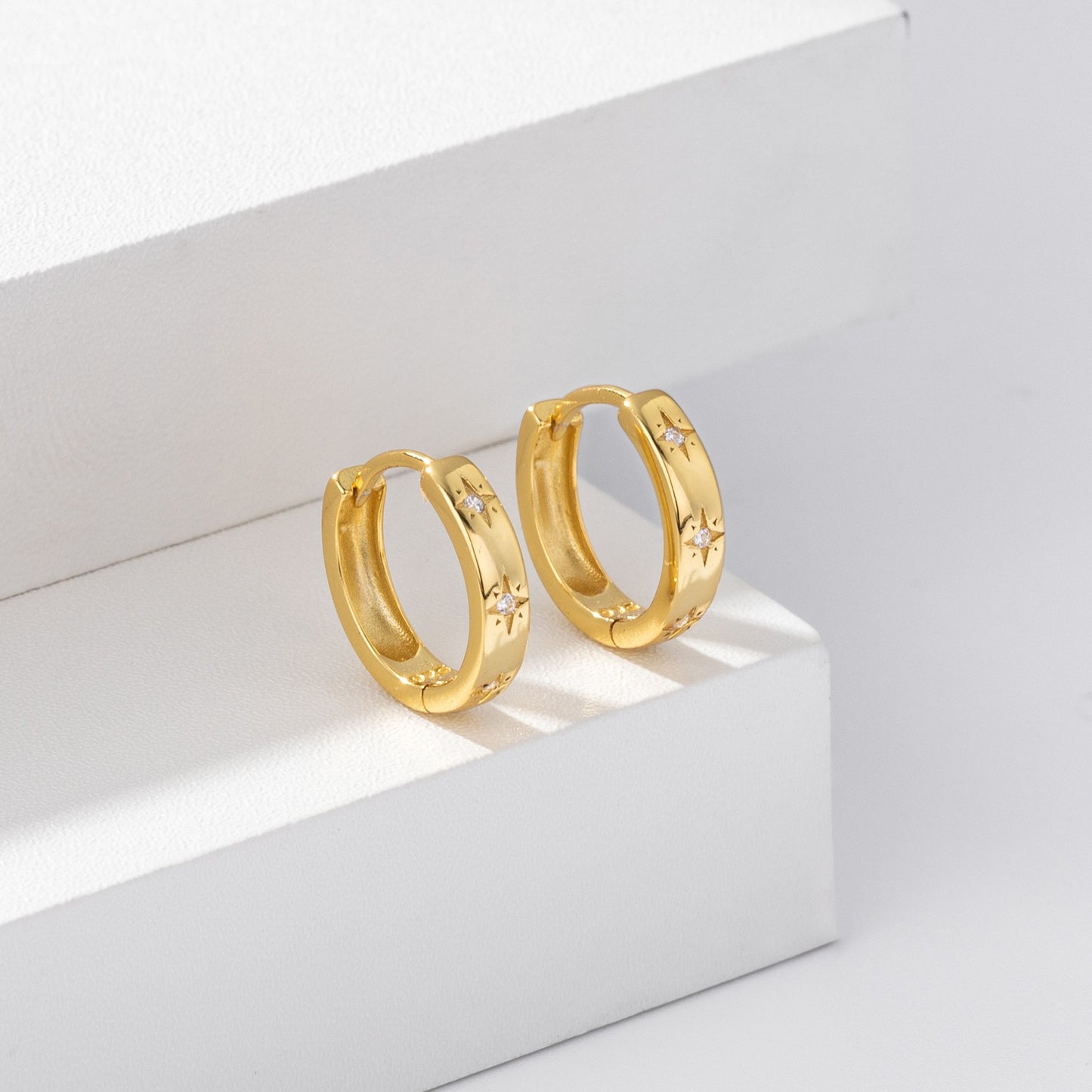 Gold plated starburst cz huggie hoop earrings close-up