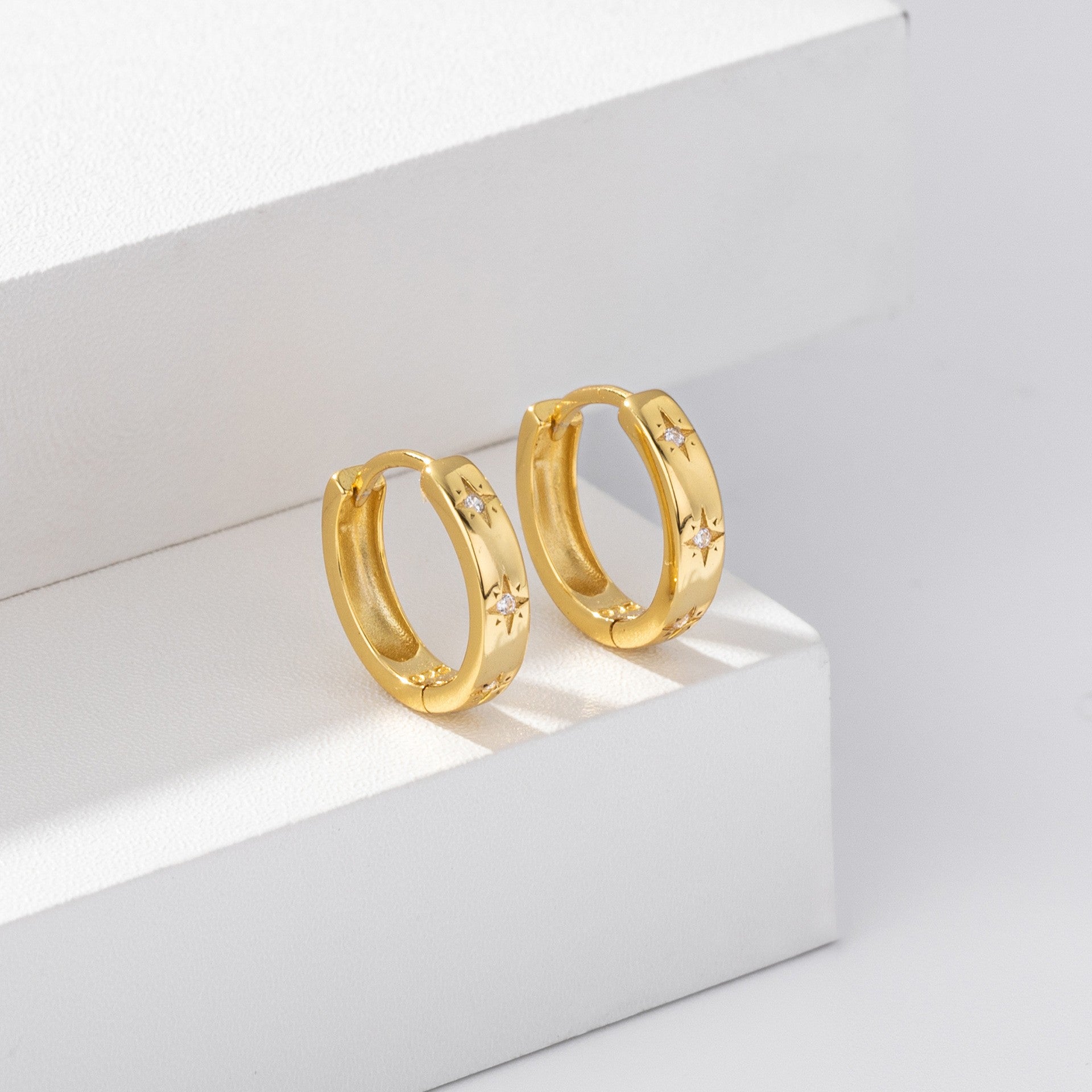 Gold plated starburst cz huggie hoop earrings close-up