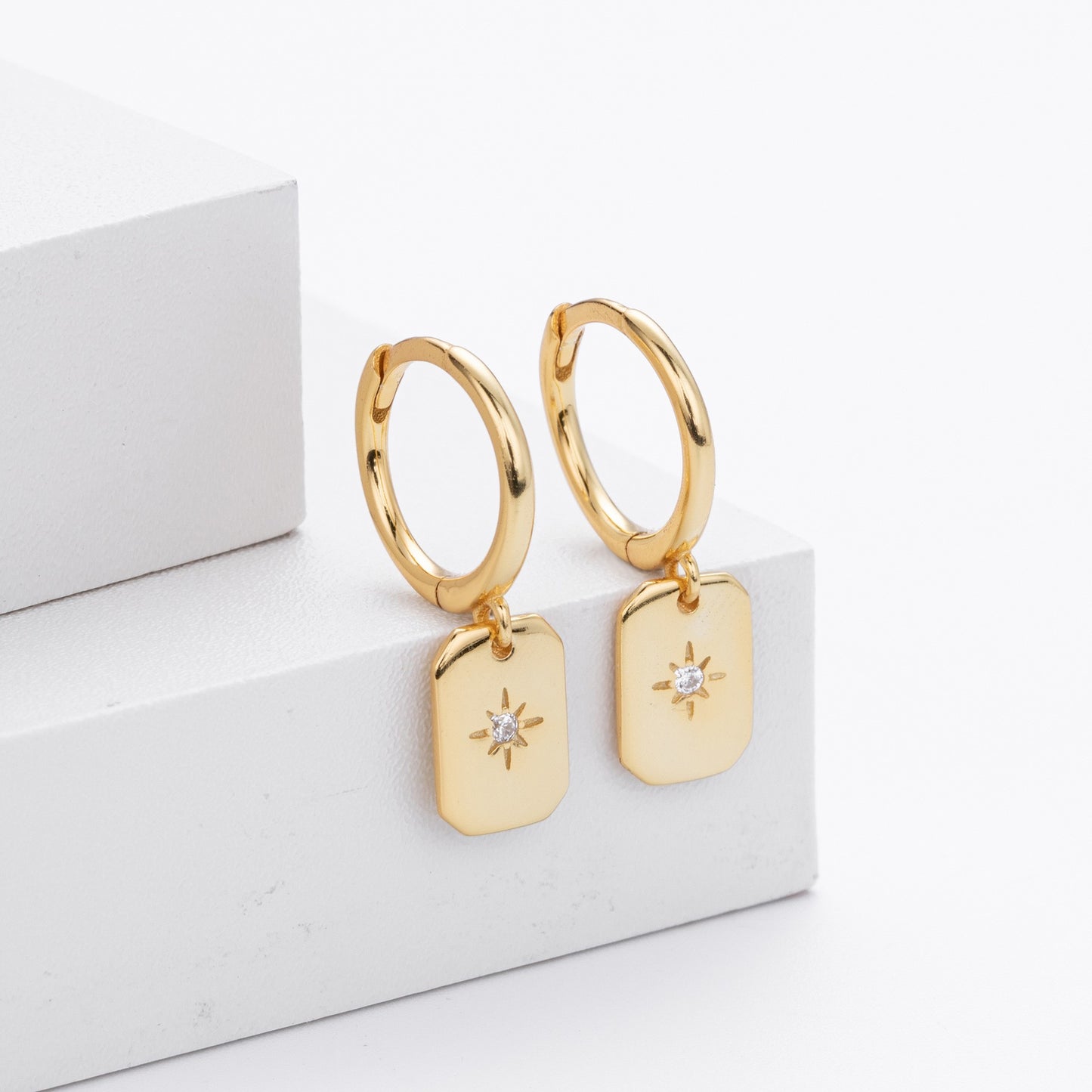 Gold plated starburst tag drop hoop earrings close-up