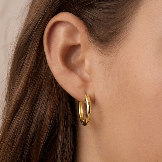 Thick smooth gold hoop earrings - worn on ear